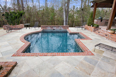 Diseño de piscina alargada clásica grande rectangular en patio trasero con adoquines de piedra natural