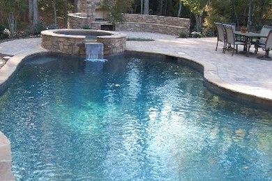 Пример оригинального дизайна: бассейн произвольной формы на заднем дворе с фонтаном и мощением тротуарной плиткой
