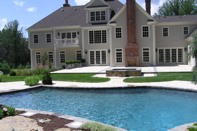 Inspiration for a large back custom shaped natural hot tub in New York with natural stone paving.