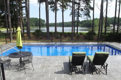 Diseño de piscina alargada rectangular en patio trasero con adoquines de hormigón