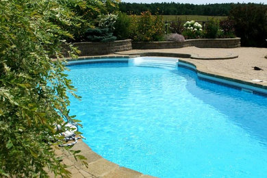 Pool - large coastal backyard stone and kidney-shaped pool idea in Other