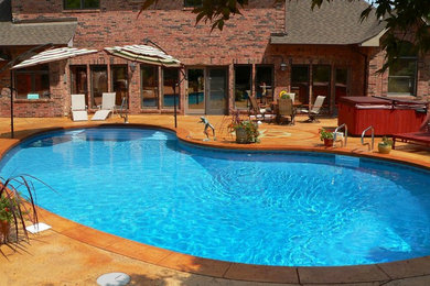 Foto de piscinas y jacuzzis tradicionales grandes tipo riñón en patio trasero con adoquines de piedra natural
