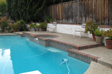 Design ideas for a back custom shaped swimming pool in Chicago with concrete slabs.