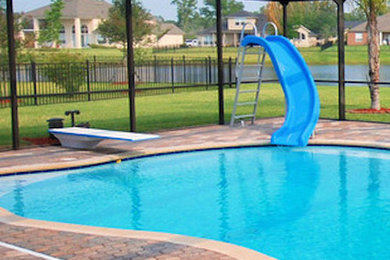 Foto de piscina con tobogán alargada grande rectangular en patio trasero