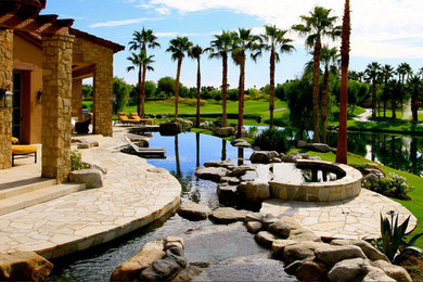Foto de piscinas y jacuzzis infinitos tradicionales grandes a medida en patio trasero con adoquines de piedra natural