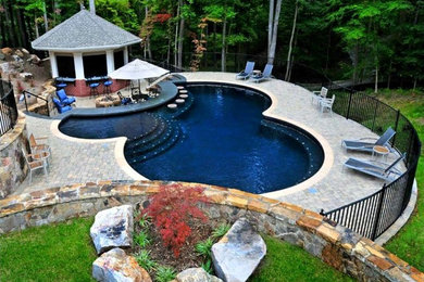 Pool house - mid-sized traditional backyard brick and round lap pool house idea in New York