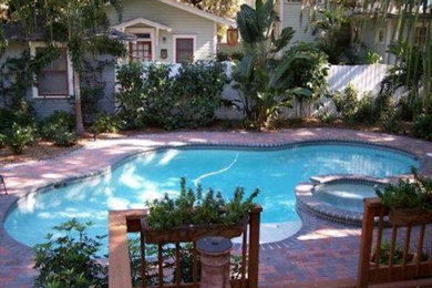 Small transitional backyard concrete paver and custom-shaped hot tub photo in Tampa