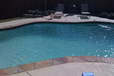 Example of a mid-sized backyard stone and custom-shaped natural pool design in Dallas