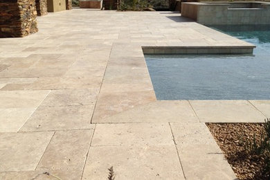 Foto de piscinas y jacuzzis de estilo americano grandes en forma de L en patio trasero con adoquines de piedra natural