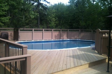 Imagen de piscina natural de tamaño medio en patio trasero con entablado