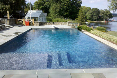Large classic back rectangular swimming pool in New York with tiled flooring.