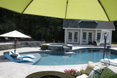 Ejemplo de piscinas y jacuzzis clásicos renovados grandes tipo riñón en patio trasero con adoquines de piedra natural