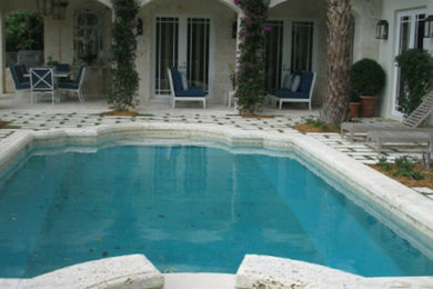 Ejemplo de piscinas y jacuzzis alargados clásicos grandes a medida en patio con adoquines de piedra natural