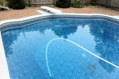 Diseño de piscina de tamaño medio en patio trasero con adoquines de ladrillo