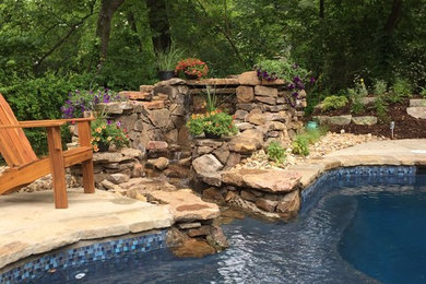 Foto de piscina con fuente rural de tamaño medio a medida en patio trasero con adoquines de piedra natural
