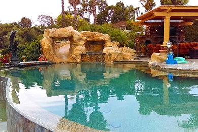 Large elegant backyard stone and custom-shaped infinity hot tub photo in Los Angeles