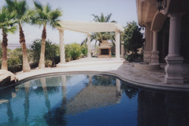 Large backyard kidney-shaped lap pool fountain photo in Las Vegas