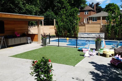 Ejemplo de piscina con fuente alargada clásica grande rectangular en patio trasero con adoquines de piedra natural