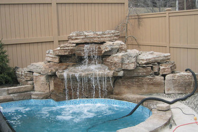 Mid-sized backyard stone and custom-shaped natural pool fountain photo in Toronto