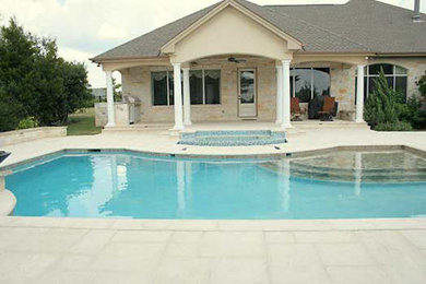 Inspiration for a medium sized mediterranean back custom shaped infinity hot tub in Austin with stamped concrete.