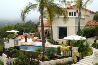 Photo of a large mediterranean side rectangular lengths swimming pool in Santa Barbara with natural stone paving.