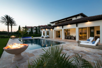 Стильный дизайн: большой прямоугольный бассейн-инфинити на заднем дворе в средиземноморском стиле с джакузи и покрытием из каменной брусчатки - последний тренд