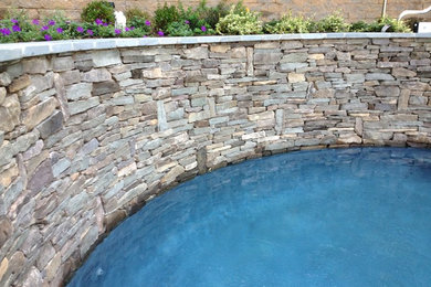 Inspiration for a mid-sized contemporary backyard stone and round natural pool fountain remodel in New York