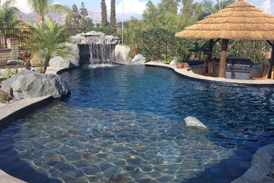 Foto de piscina exótica de tamaño medio a medida en patio trasero