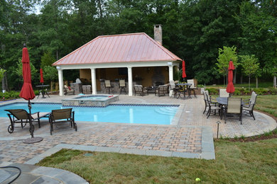 This is an example of a medium sized contemporary back rectangular natural swimming pool in DC Metro with a pool house and concrete paving.