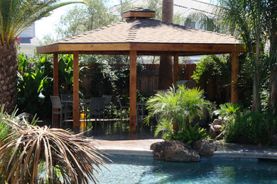 Modelo de piscina de tamaño medio en patio trasero con suelo de hormigón estampado