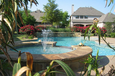Diseño de piscina tradicional grande a medida en patio trasero con losas de hormigón