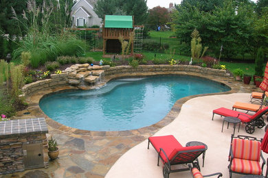 Diseño de piscina con fuente natural tipo riñón en patio trasero con adoquines de piedra natural
