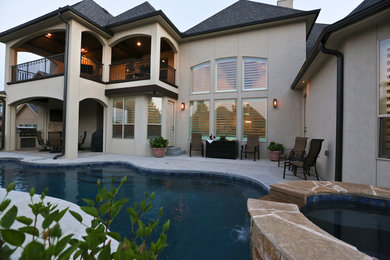 Inspiration for a large transitional backyard concrete paver and custom-shaped lap hot tub remodel in Other