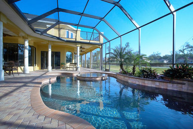 Inspiration for a mid-sized backyard concrete paver and custom-shaped natural hot tub remodel in Tampa