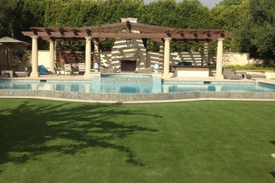 Foto de piscina con fuente alargada mediterránea grande rectangular en patio trasero con suelo de baldosas