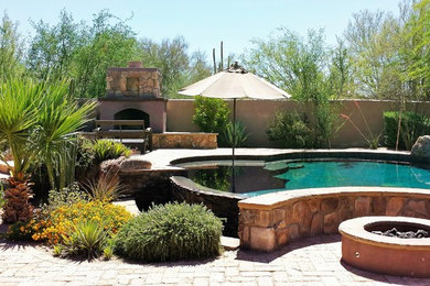 Diseño de piscina con fuente natural clásica grande a medida en patio trasero con adoquines de piedra natural