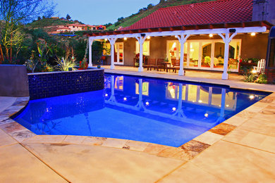Esempio di una piscina personalizzata dietro casa con una dépendance a bordo piscina e pavimentazioni in pietra naturale