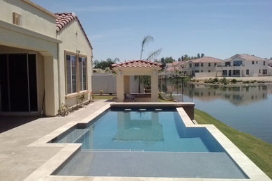 Foto di una piscina a sfioro infinito mediterranea personalizzata di medie dimensioni e dietro casa con una vasca idromassaggio e piastrelle