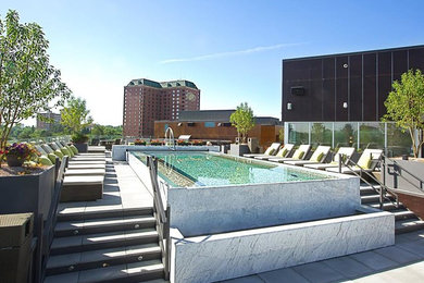 Foto de piscina elevada actual de tamaño medio rectangular en azotea con adoquines de hormigón
