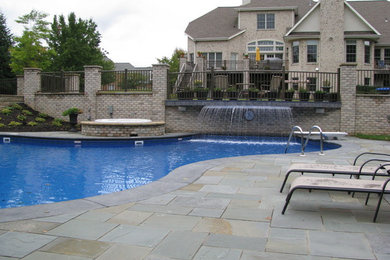 Diseño de piscinas y jacuzzis clásicos grandes a medida en patio trasero con adoquines de piedra natural