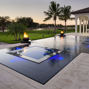 Diseño de piscinas y jacuzzis infinitos, actuales, grandes, a medida, en patio trasero, con suelo de baldosas