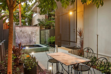 Immagine di un piccolo patio o portico design in cortile con fontane e piastrelle
