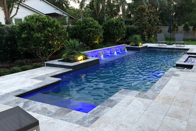 Diseño de piscinas y jacuzzis alargados modernos grandes a medida en patio trasero con suelo de baldosas