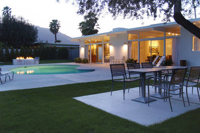 Large trendy backyard concrete and custom-shaped pool photo in Los Angeles