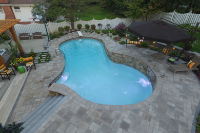 Hot tub - mid-sized traditional backyard brick and custom-shaped natural hot tub idea in Chicago
