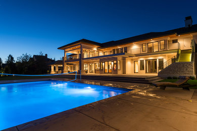 Photo of a large contemporary back rectangular lengths swimming pool in Boise with concrete slabs.