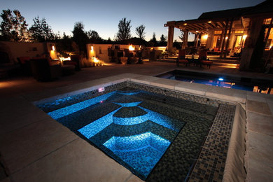 Photo of a large classic back rectangular lengths hot tub in Denver with natural stone paving.