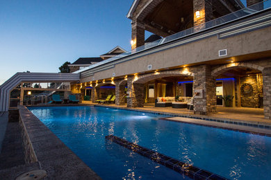 Diseño de piscina elevada ecléctica extra grande rectangular en patio con adoquines de hormigón