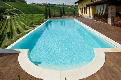 Imagen de casa de la piscina y piscina natural campestre de tamaño medio rectangular en patio delantero con entablado