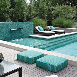 Idee per una grande piscina monocorsia design rettangolare dietro casa con pedane